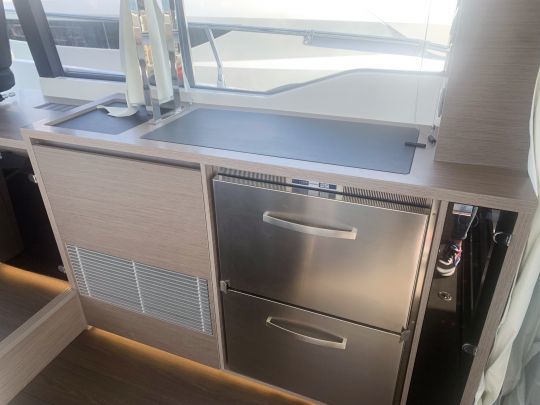En vis-Ã -vis de la cuisine, un meuble accueille le rÃ©frigÃ©rateur