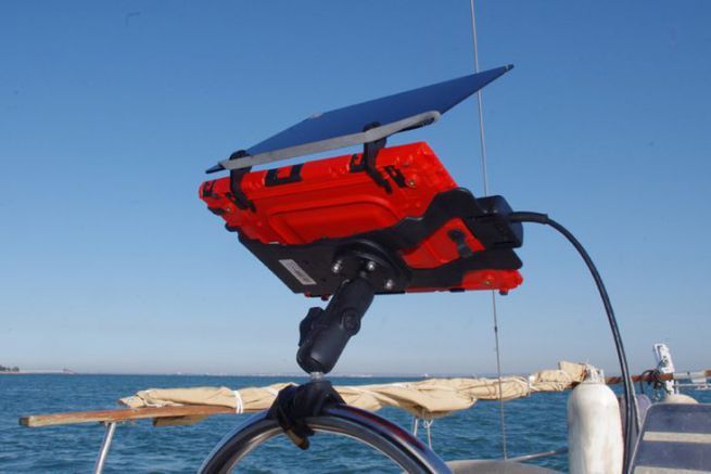 Un estante en su proteccin con el visor solar en el timn de un velero